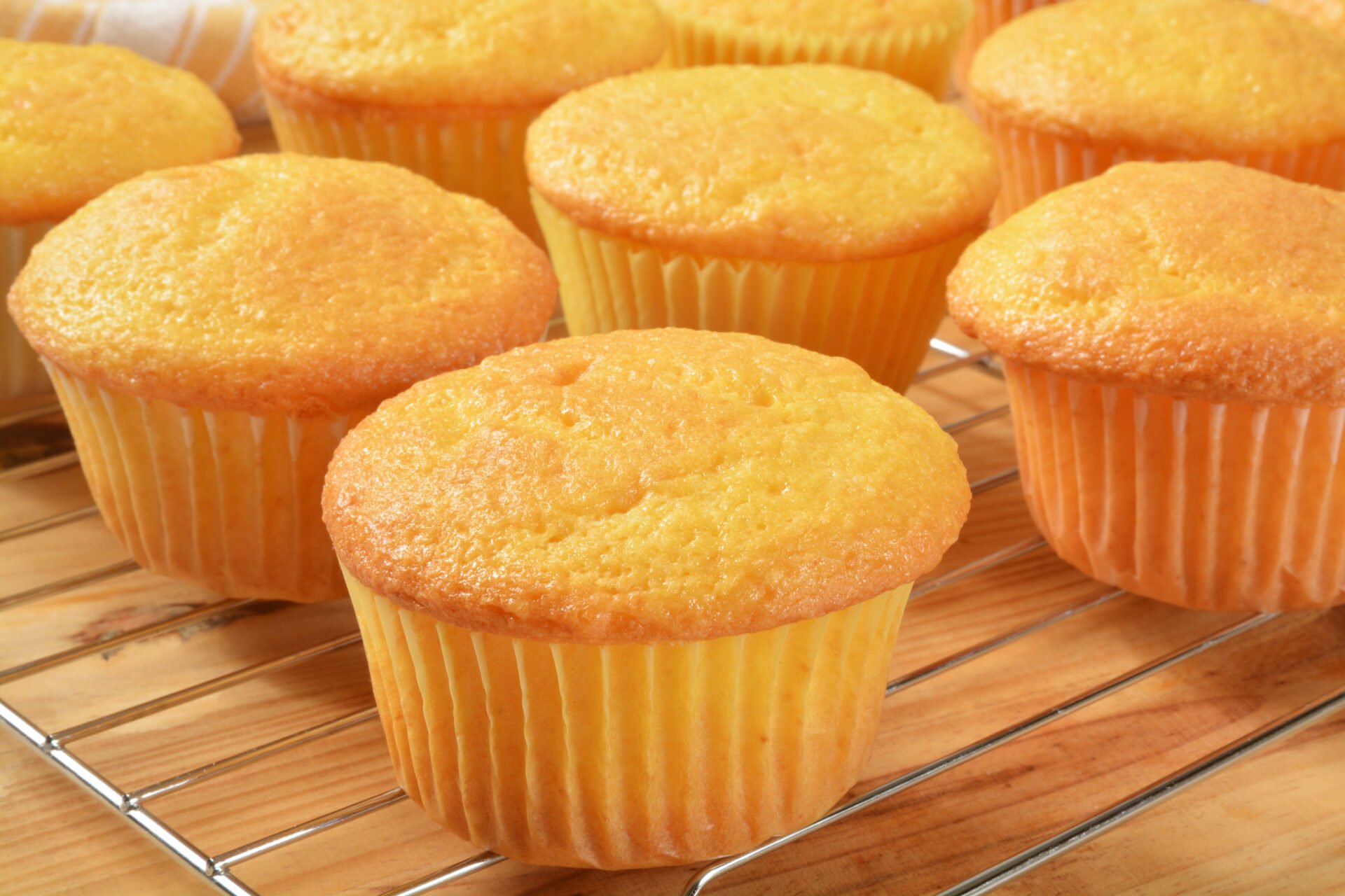 Fresh baked yellow cupcakes on a cooling rack