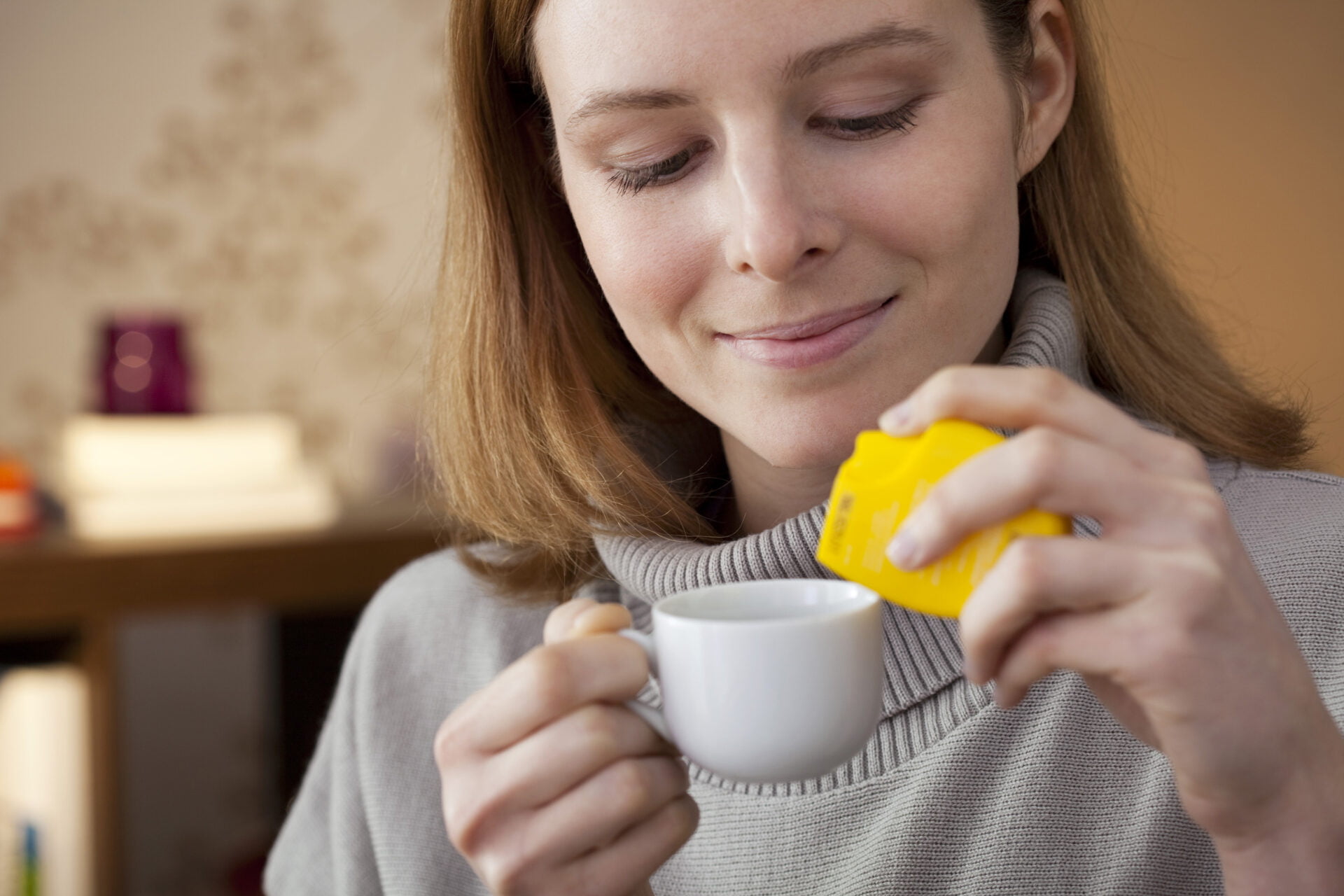 woman putting toxic sweetener in her tea