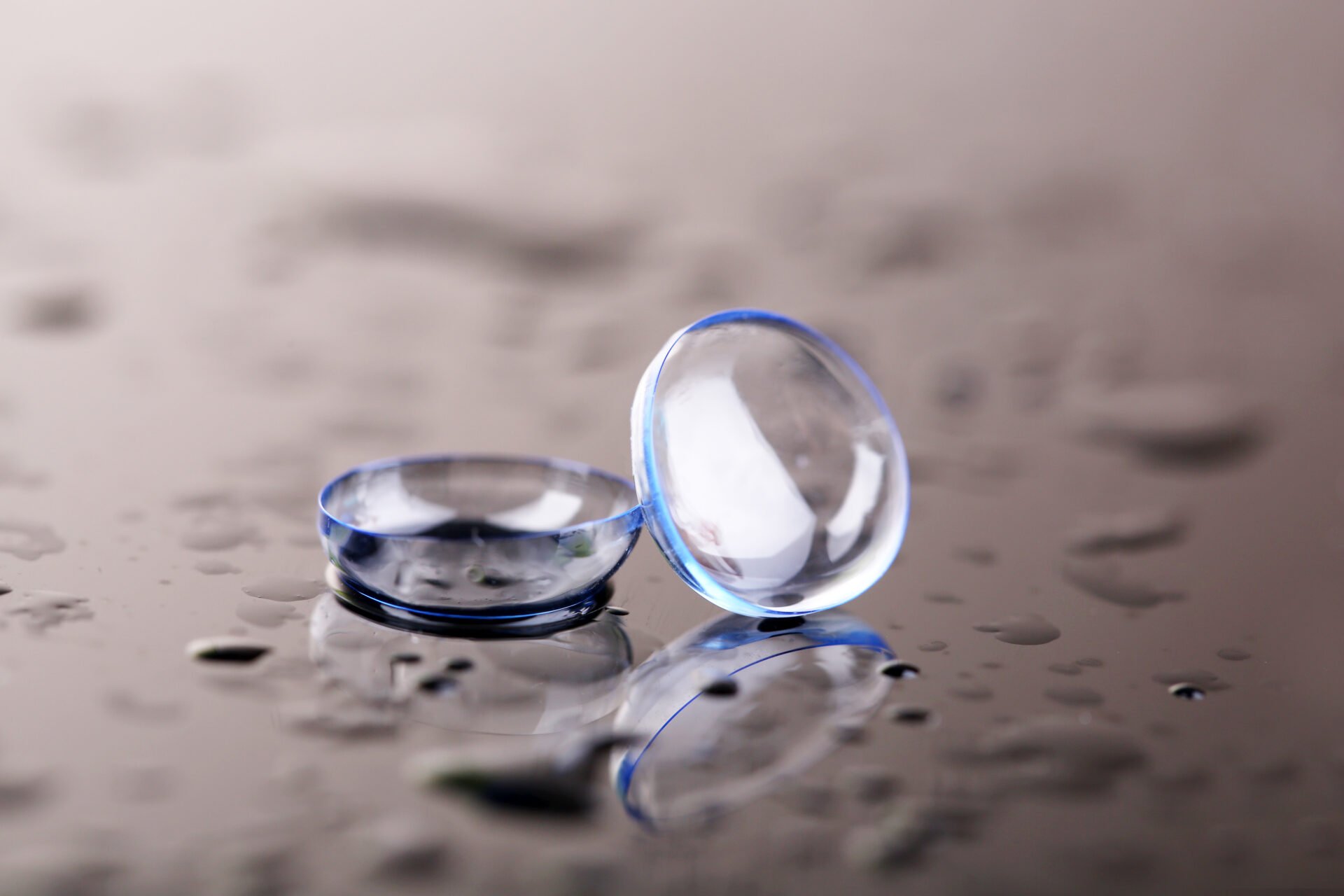 Contact lenses with water drops on bright background