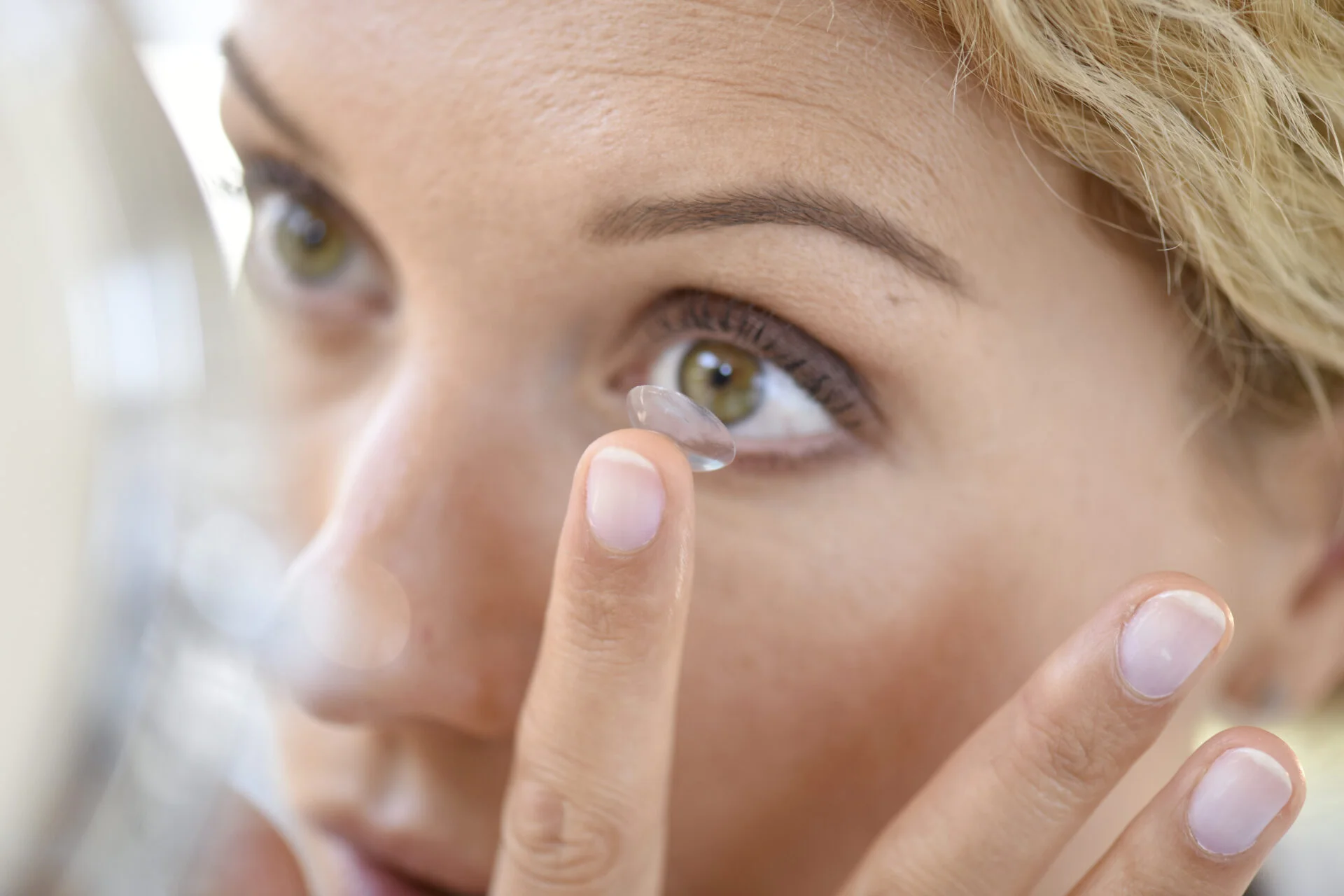 Woman putting contact lenses on