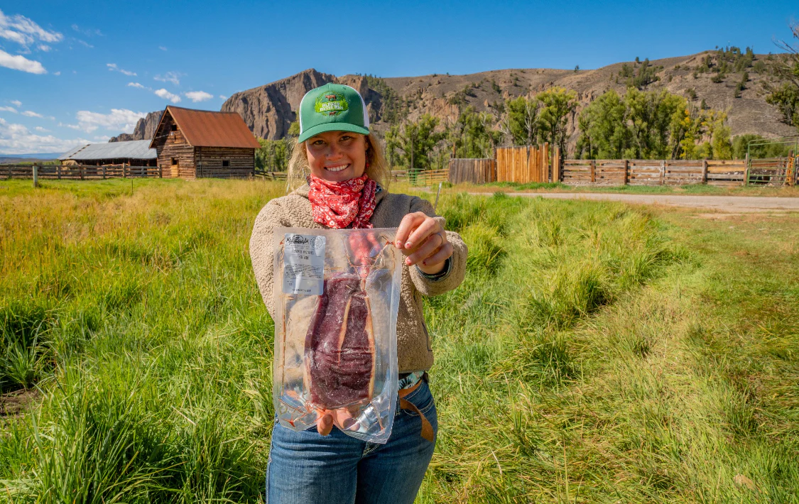 Chloe of Parker Pastures holding up grass-fed beef