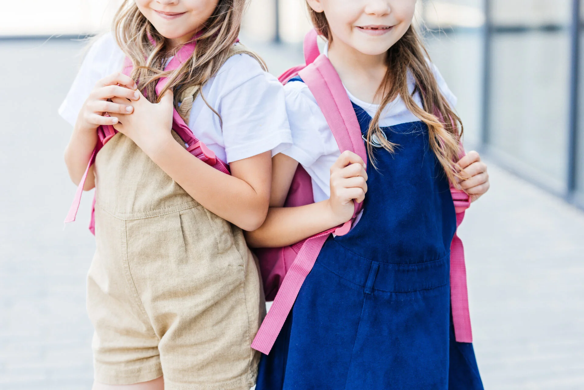 Two girls wearing pink backpacks with no indications of PFAS "forever chemicals" on the fabric