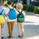 three young boys with backpacks walking to class