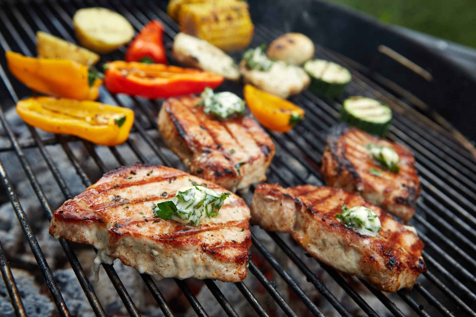 prepared meat with butter pieces and vegetables on grill