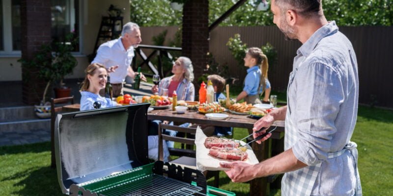 Man BBQing for family outside