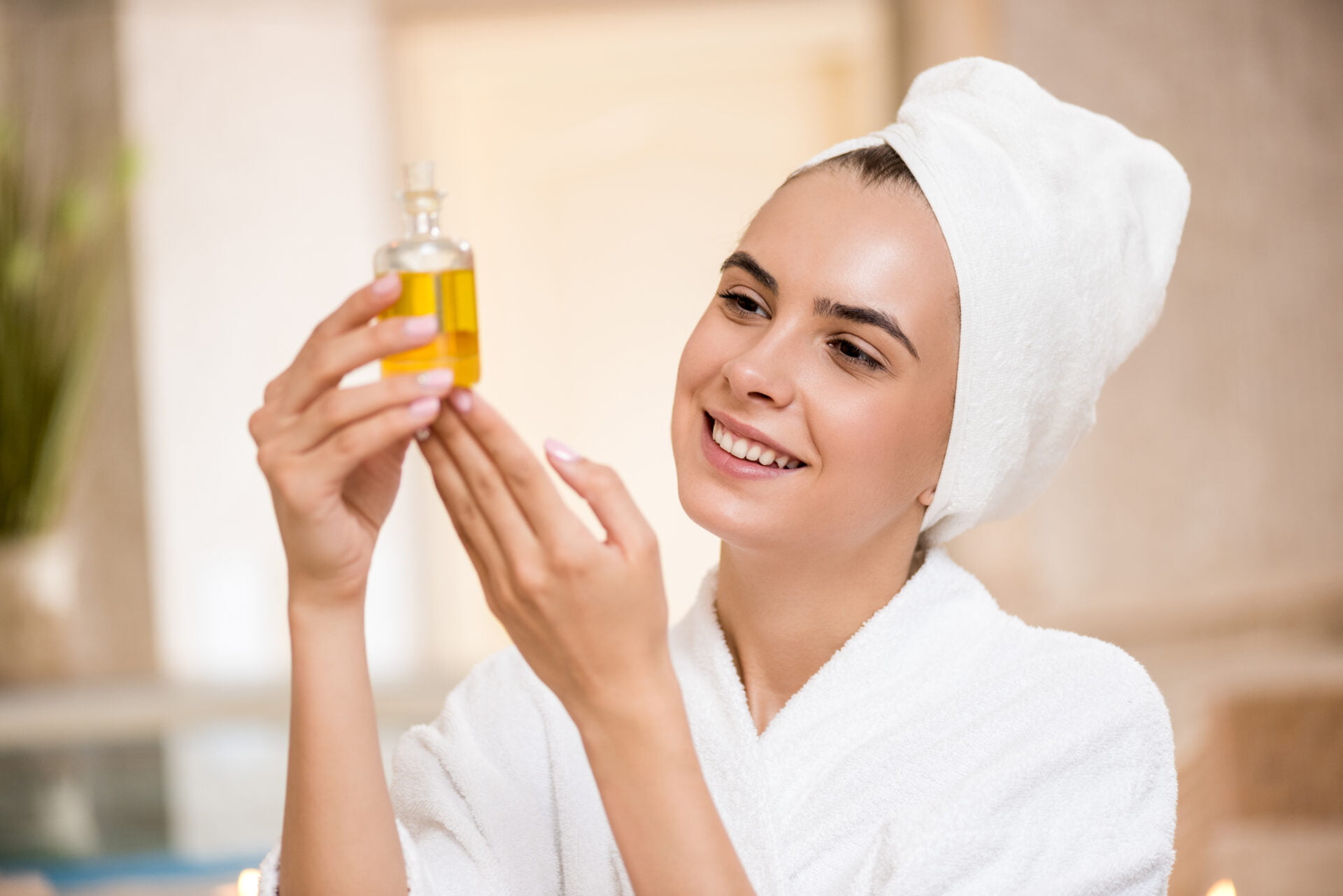 Woman holding up her favorite natural body oil free from problematic ingredients