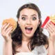 Woman holds up fast food with PFAS inside the packaging that she is about to eat