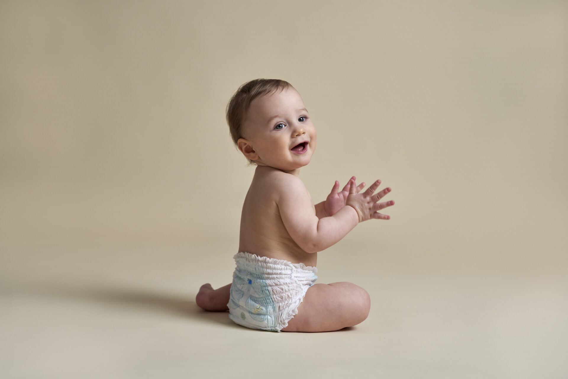 Little baby sitting on nude background