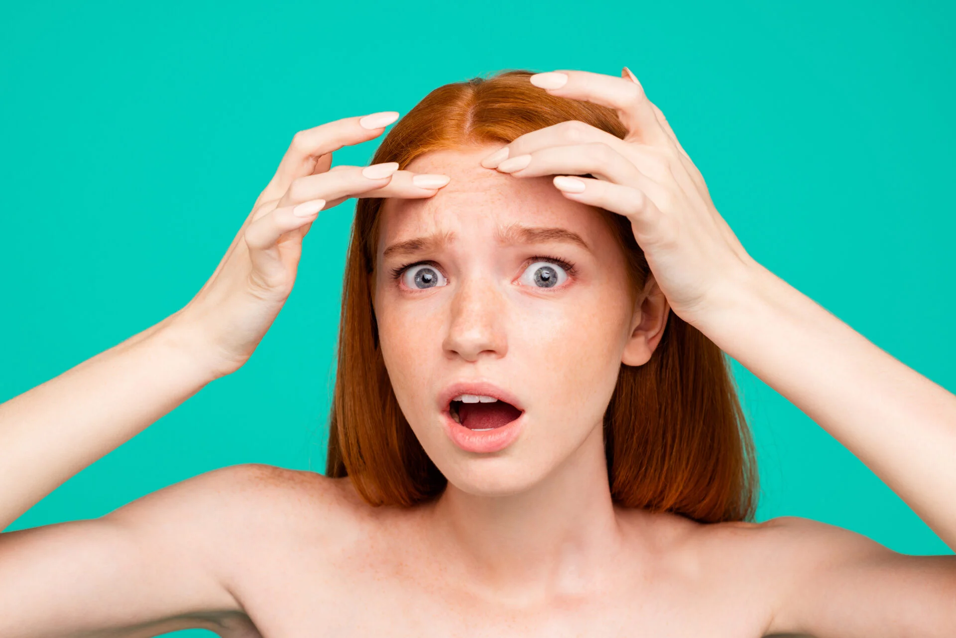 Anti acne. Close-up portrait of worried nice attractive red-haired girl with shiny pure clean skin, touching forehead, isolated over green turquoise background
