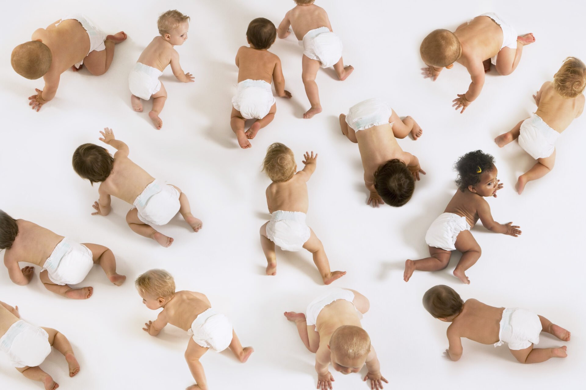 Babies crawling on the floor with diapers on