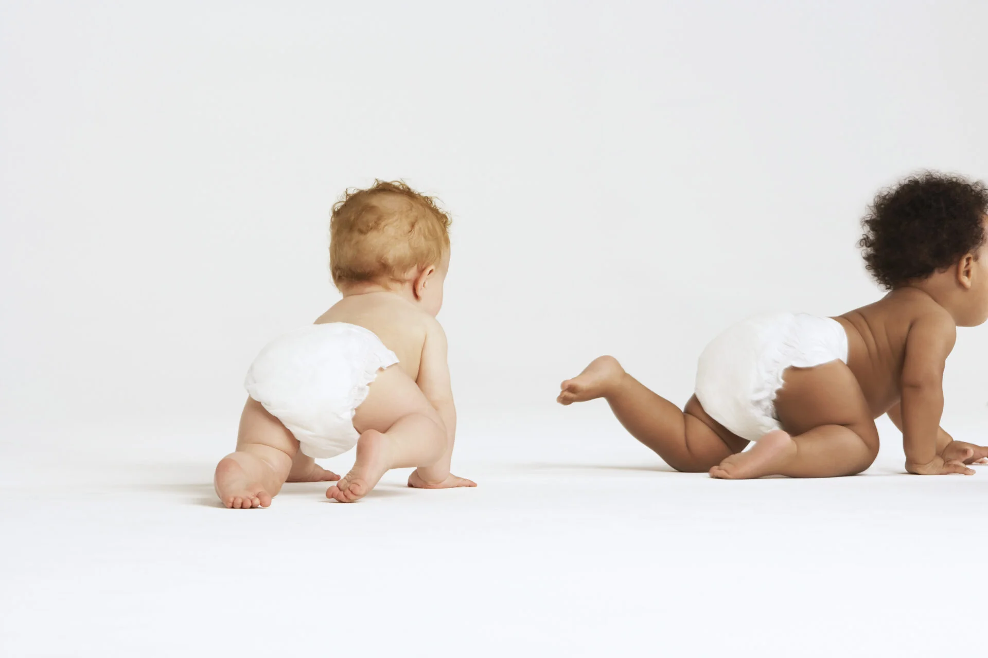 Babies with diapers on crawling away