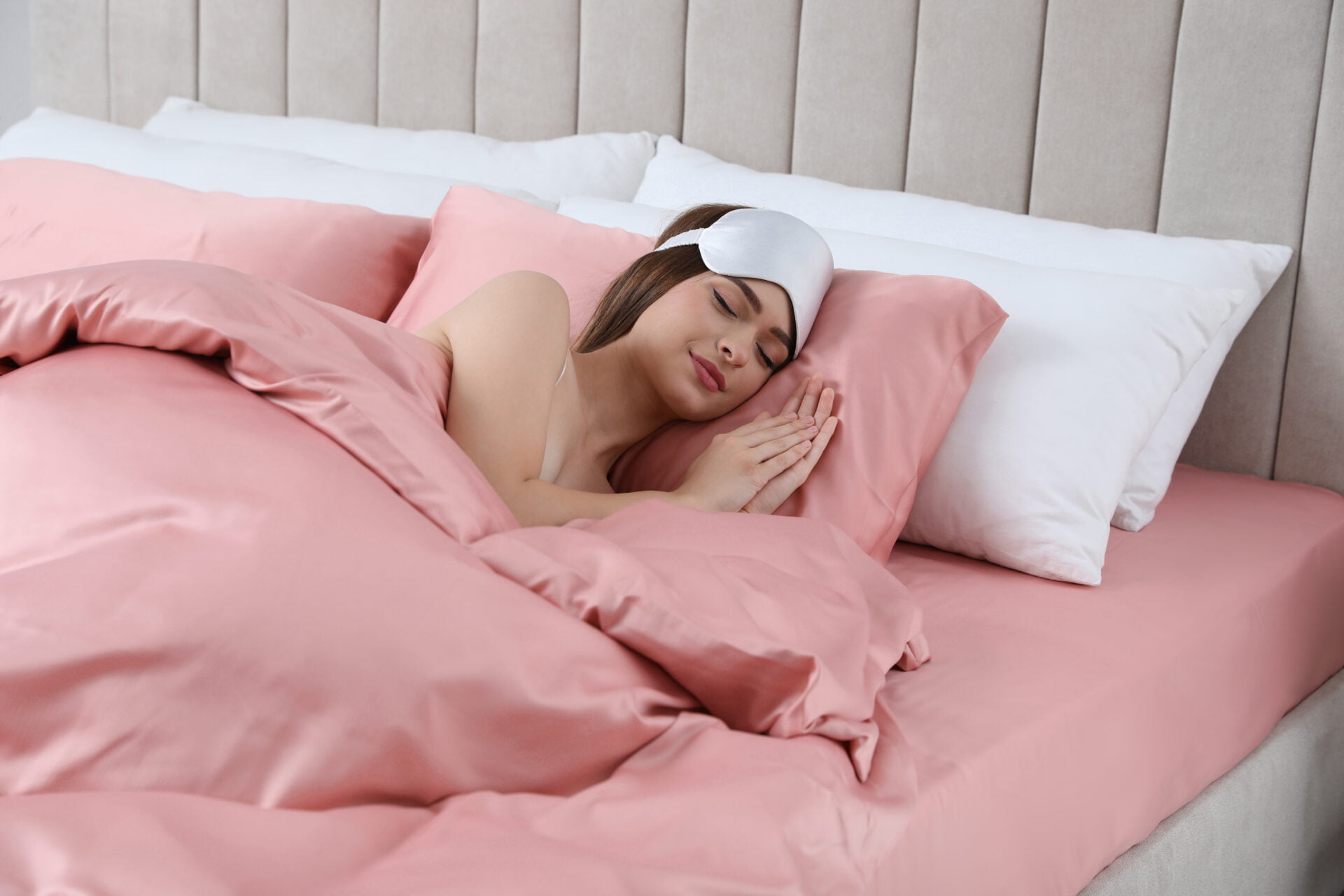 Young woman sleeping in comfortable bed with blankets 