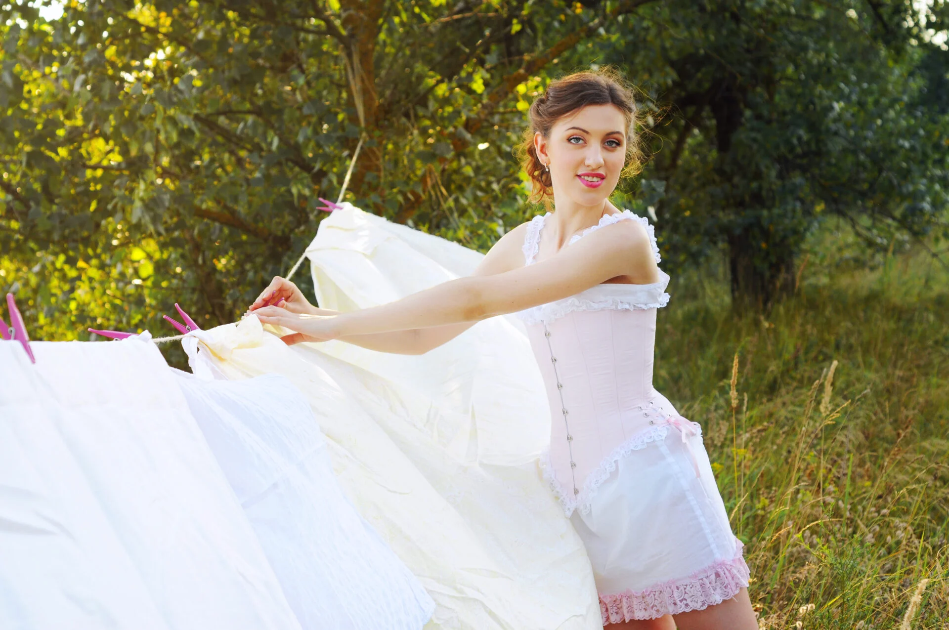 Young attractive woman drying her laundry outdoors