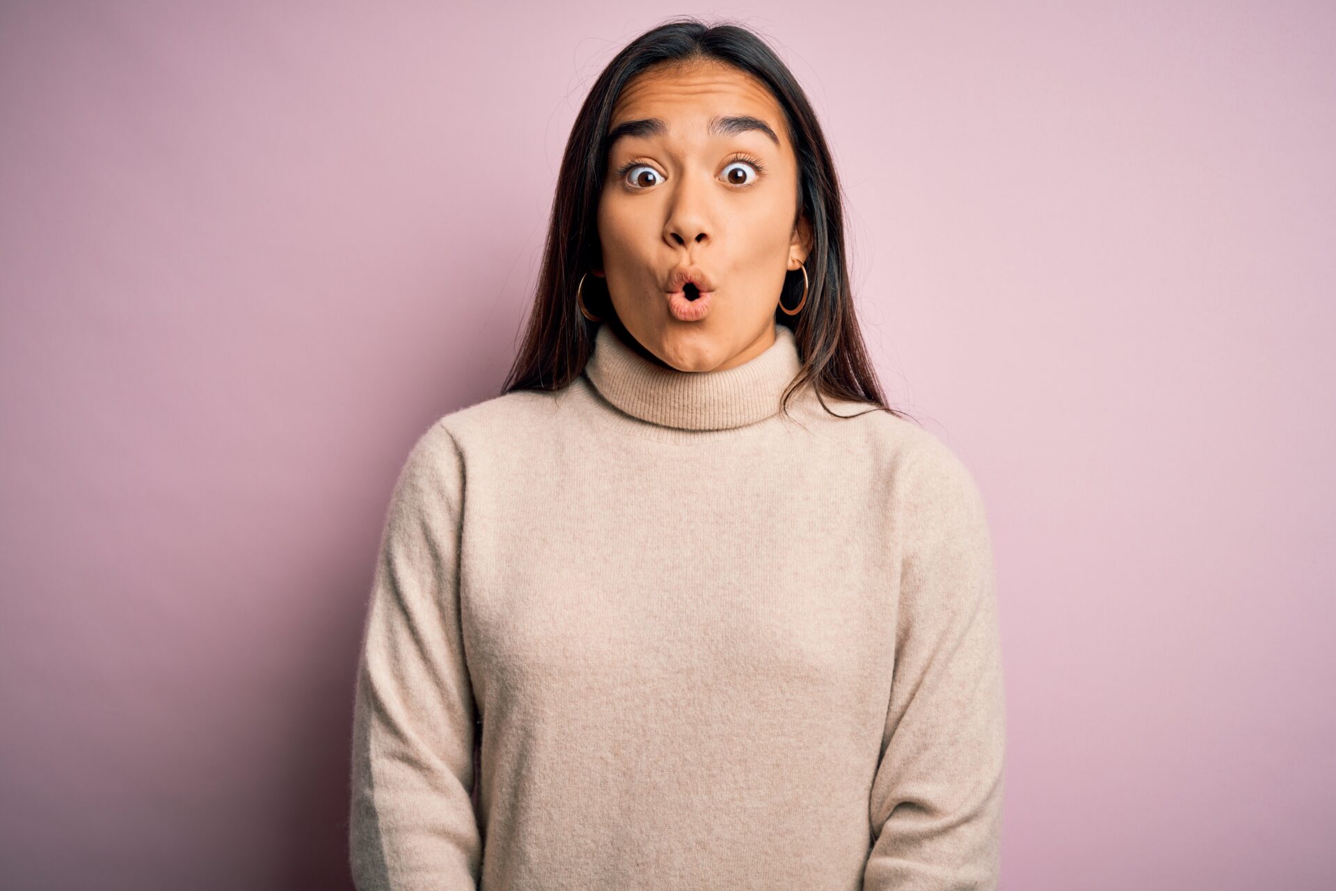 Young beautiful asian woman wearing casual turtleneck sweater over pink background afraid and shocked with surprise expression, fear and excited face.