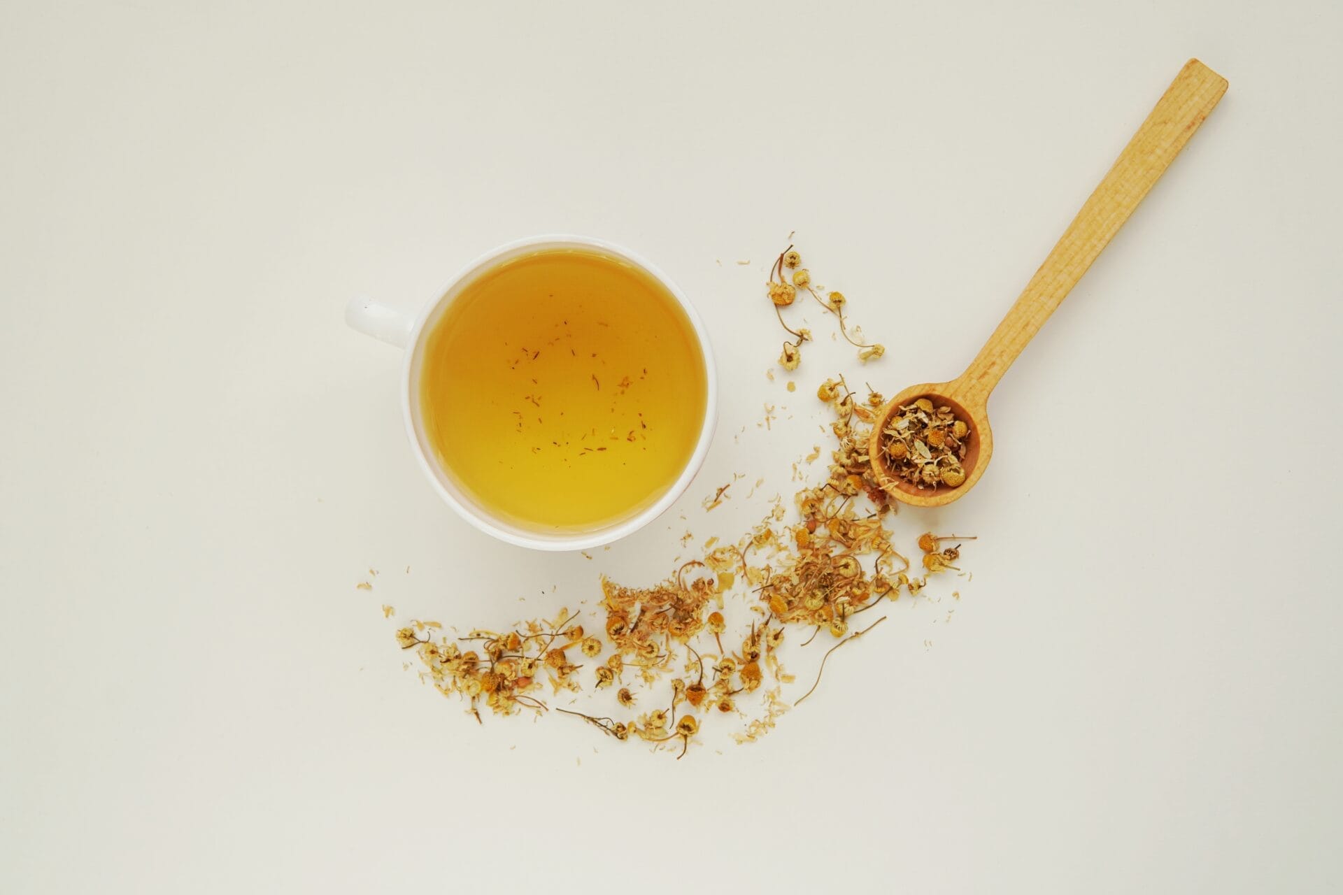 dried chamomile flowers and tea sitting on the table